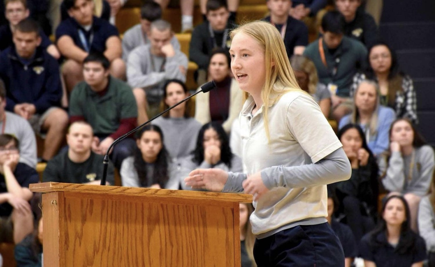 A student speaking at a podium to other students
